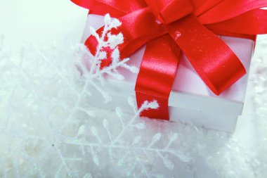 Kırmızı kurdeleli beyaz hediye kutusu.