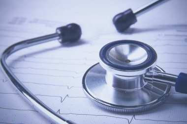 Masada yatan elektrokardiyogramda stetoskop.