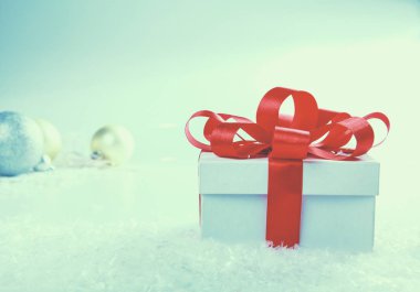 Kırmızı kurdeleli beyaz hediye kutusu.