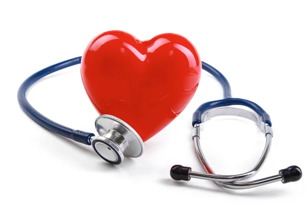 Красное сердце и стетоскоп на столе — стоковое фото