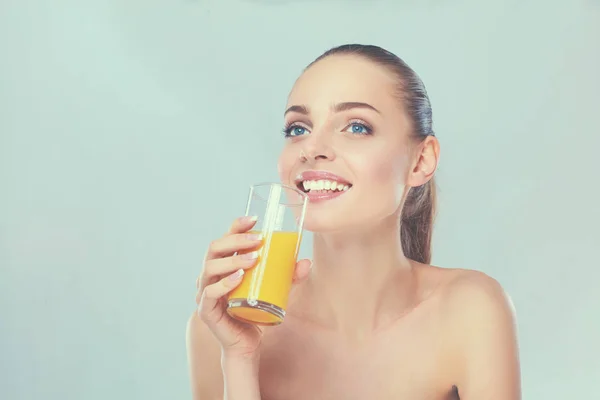Glada leende flicka med handduk håller ett glas apelsinjuice — Stockfoto