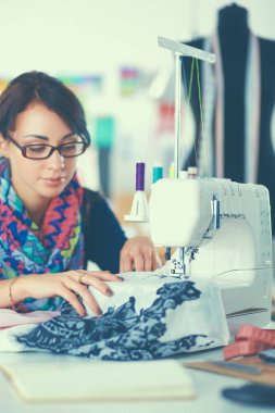 Çalışırken dikiş diken genç bir kadın.