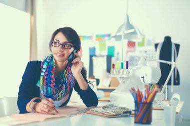 Genç terzi kâğıt üzerinde kıyafet deseni tasarlıyor.