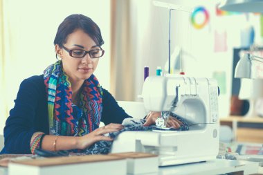 Çalışırken dikiş diken genç bir kadın.