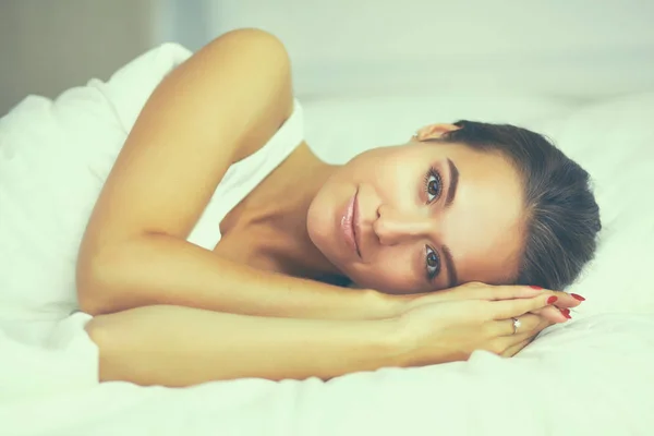 Ung vacker kvinna ligger i sängen hemma — Stockfoto