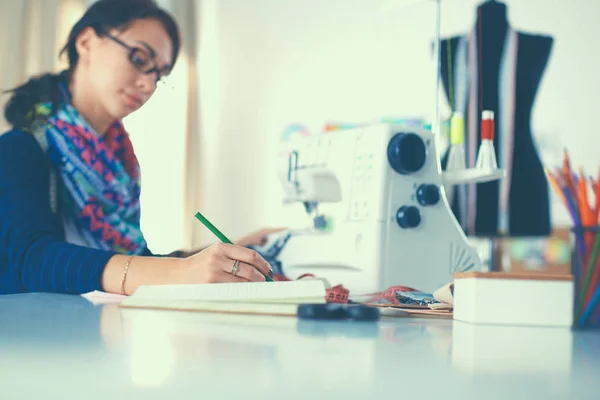 Genç terzi kâğıt üzerinde kıyafet deseni tasarlıyor. — Stok fotoğraf