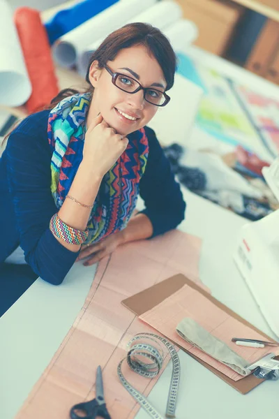 Hermoso diseñador de moda sentado en el escritorio en el estudio —  Fotos de Stock