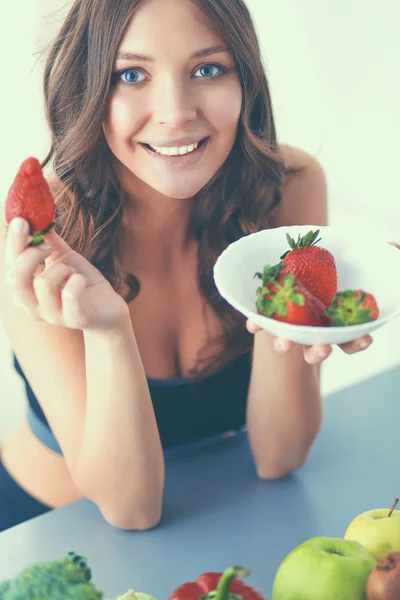 笑っている女性がイチゴを食べている。女性の顔の肖像画を閉じる — ストック写真