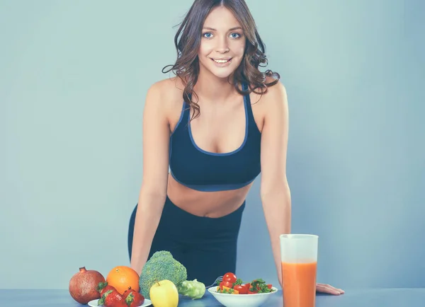 Młoda i piękna kobieta stojąca przy biurku z warzywami — Zdjęcie stockowe