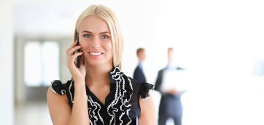 Ofiste cep telefonu kullanan güzel bir iş kadını.