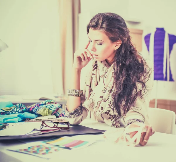Leende kvinnlig modedesigner sitter vid skrivbordet — Stockfoto
