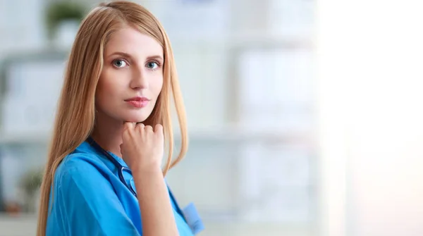 Doctor woman is standing in the near window — Stock Photo, Image