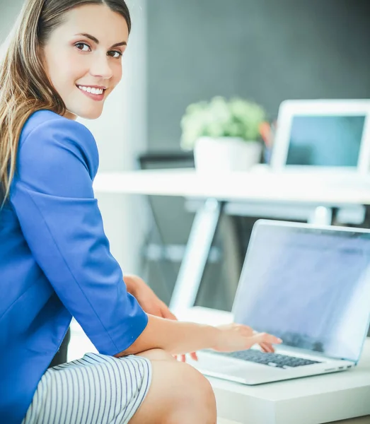 Mulher sentada na mesa com laptop — Fotografia de Stock