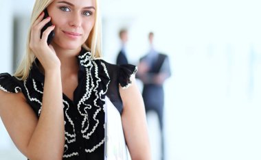 Ofiste cep telefonu kullanan güzel bir iş kadını.