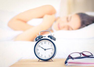 Yatakta rahat ve mutlu bir şekilde yatan güzel bir genç kadın.