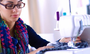 Çalışırken dikiş diken genç bir kadın.