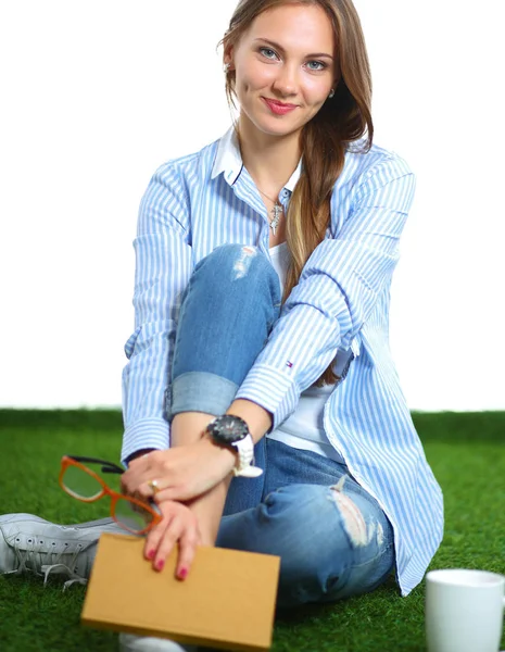 Giovane donna seduta con libro sull'erba — Foto Stock