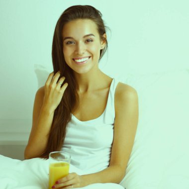 Genç ve güzel bir kadın yatakta yatıyor.