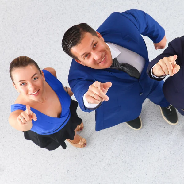 Gente de negocios de pie juntos mirando hacia arriba y apuntando a la cámara. — Foto de Stock