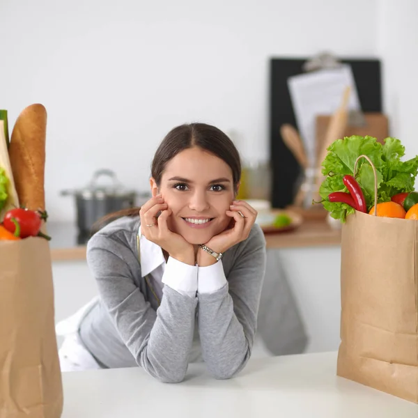 Ritratto di una donna sorridente che cucina nella sua cucina seduta — Foto Stock