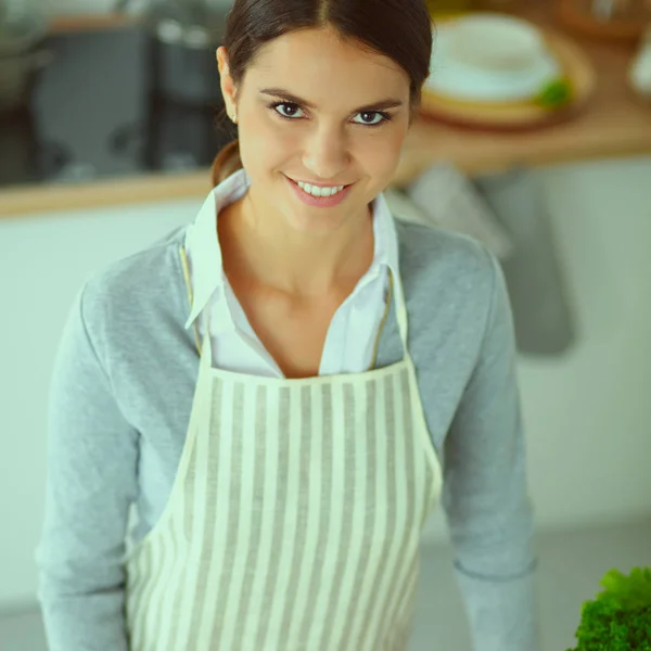 Vrouw maken van gezonde voeding staande glimlachend in keuken — Stockfoto