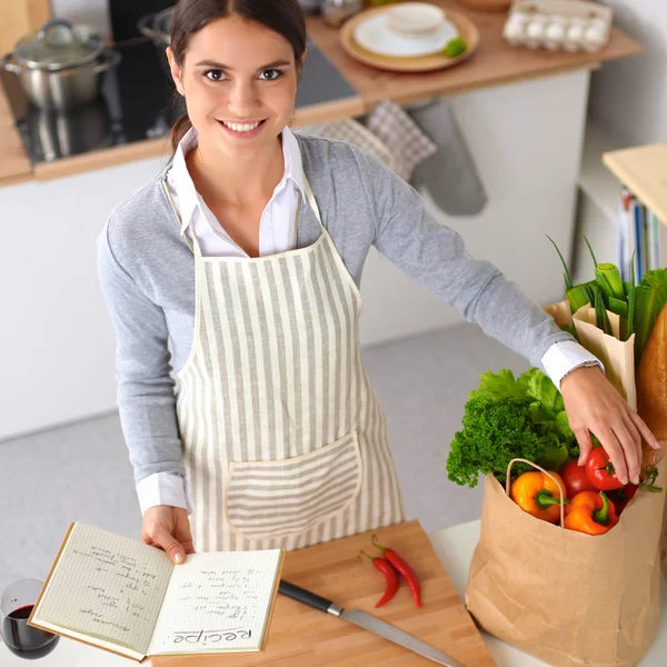 Vrouw maken van gezonde voeding staande glimlachend in keuken — Stockfoto