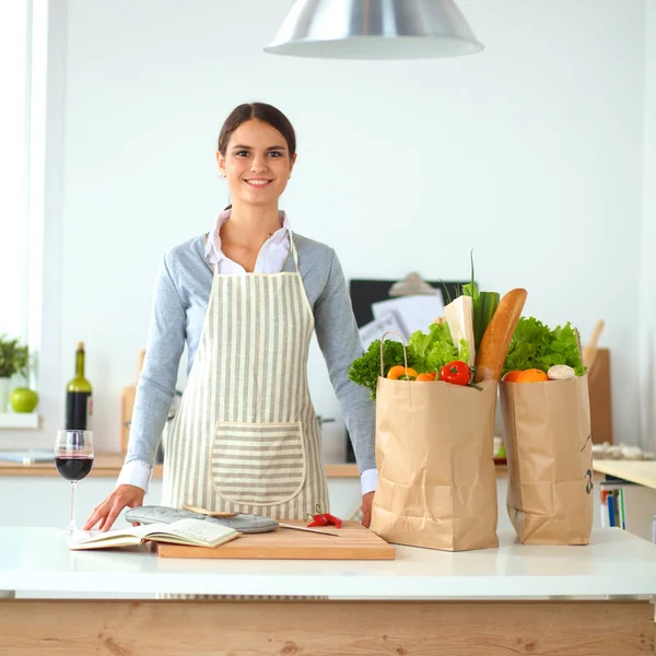 Portret van een lachende vrouw die kookt in haar keuken — Stockfoto