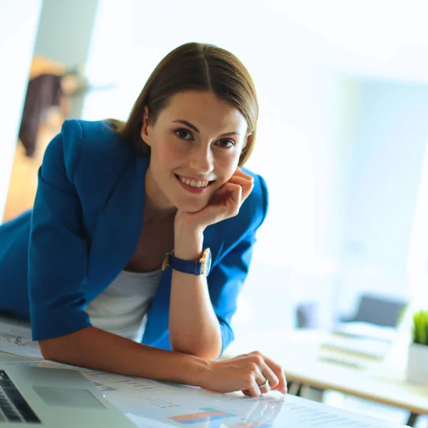 Retrato de una hermosa mujer de negocios de pie cerca de su lugar de trabajo —  Fotos de Stock