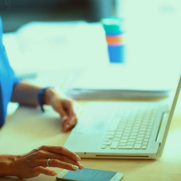 Woman sitting on the desk with laptop — Stock Photo, Image