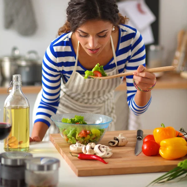 Young woman preparing salad in the kitchen — Stock Photo, Image