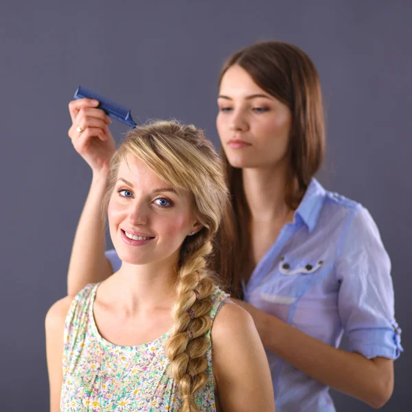 Молодая женщина парикмахер сделать прическу девушка в салоне — стоковое фото