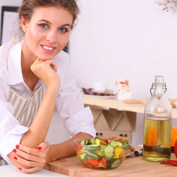 Mujer joven comiendo ensalada fresca en la cocina moderna —  Fotos de Stock