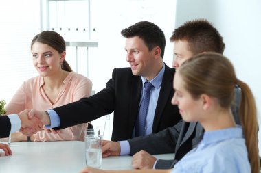 İş adamları toplantıda, ofiste oturup tartışıyorlar.