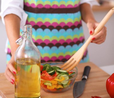 Gülümseyen genç kadın taze salata hazırlıyor.