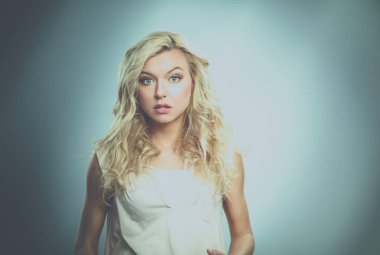 ayakta, gri arka plan üzerinde izole genç kadın