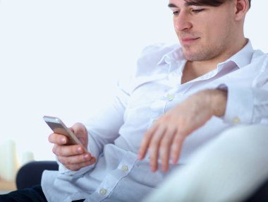 Genç işadamı ofiste çalışıyor, masada oturuyor.