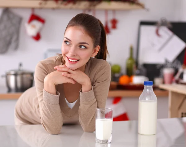 Hymyilevä houkutteleva nainen ottaa aamiaisen keittiössä sisustus — kuvapankkivalokuva