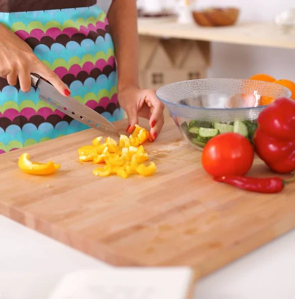 Jovem mulher preparando salada na cozinha — Fotografia de Stock