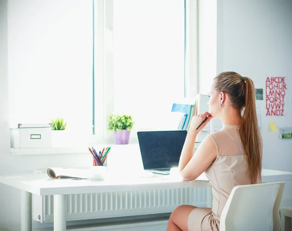 Kvinna med dokument sittande på skrivbordet och laptop — Stockfoto