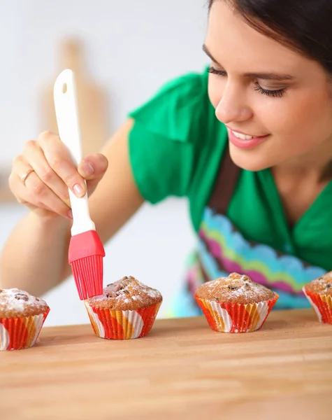 Jonge vrouw is het maken van cakes in de keuken — Stockfoto