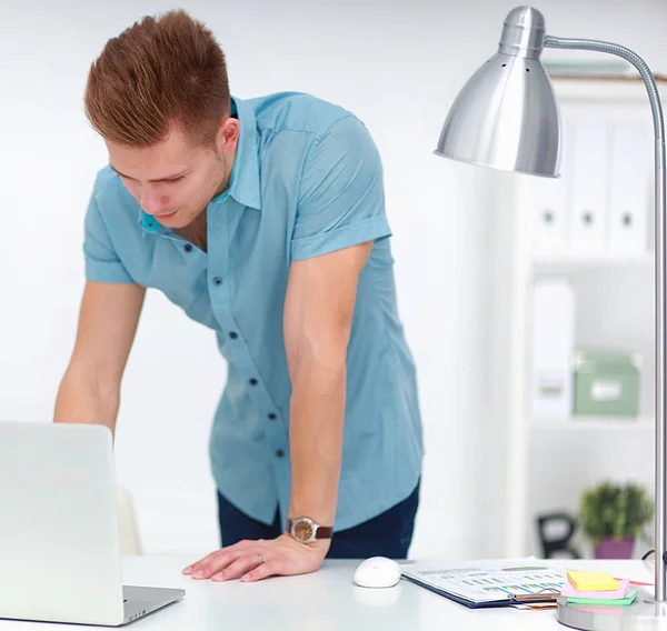 Jeune homme d'affaires travaillant au bureau, debout près du bureau — Photo