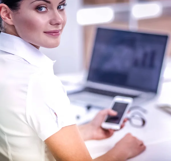 Femme d'affaires envoyer un message avec smartphone assis dans le bureau — Photo