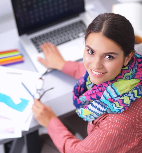 Young attractive female fashion designer working at office desk, drawing while talking on mobile — Stock Photo, Image