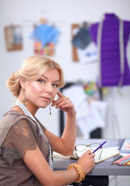 Stüdyoda çalışan genç moda tasarımcısı.