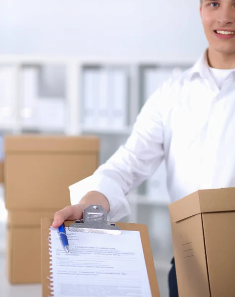 Delivery man with  parcel and a tablet standing in office — Stock Photo, Image