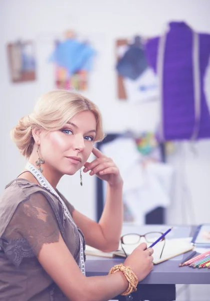 Junge Modedesignerin arbeitet im Atelier. — Stockfoto