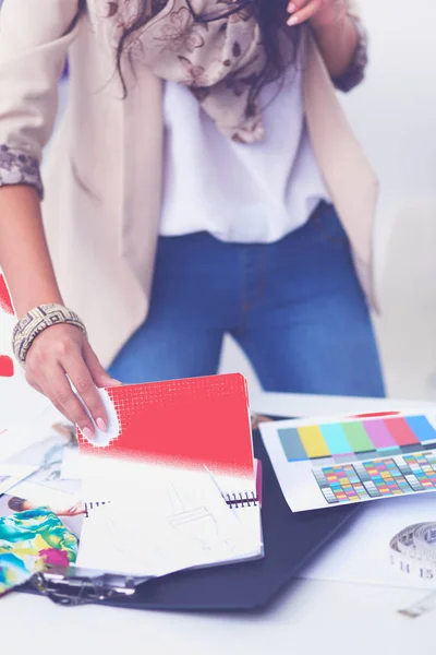 Leende kvinnlig modedesigner sitter vid skrivbordet — Stockfoto