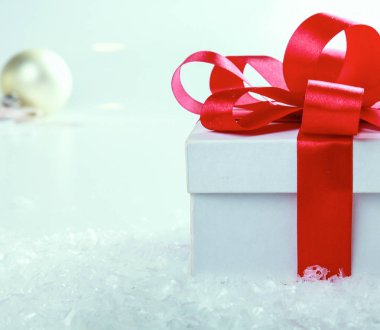 Kırmızı kurdeleli beyaz hediye kutusu.