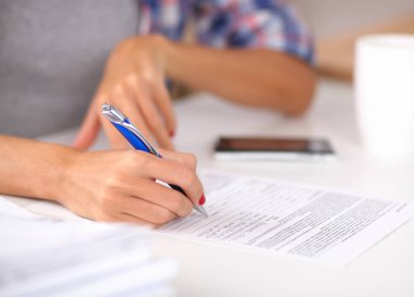 Güzel genç bayan not defterine bir şeyler yazıyor.