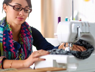 Çalışırken dikiş diken genç bir kadın.